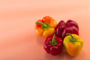 Tatlı bellpepper. İki kırmızı ve hafif pembe bir arka plan üzerinde iki sarı-turuncu tatlı bellpeppers. Dört adet. Stüdyo ışık. Üstten görünüm