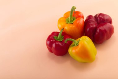 Tatlı bellpepper. İki kırmızı ve bej renkli arka plan üzerinde iki sarı-turuncu tatlı bellpeppers. Dört adet. Stüdyo ışık. Üstten görünüm