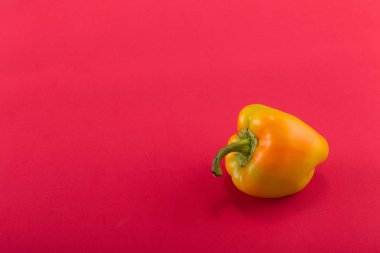 Tatlı bellpepper. Turuncu-sarı kırmızı bir arka plan üzerinde tatlı bellpepper. Bir tane. Stüdyo ışık. Üstten görünüm