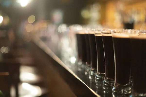 A party. A pub. Bar. Club. A restaurant. Beer glasses with dark beer. Dark beer poured into beer glasses