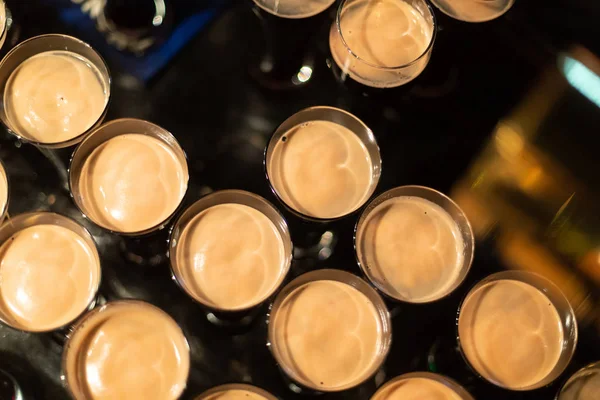 A party. A pub. Bar. Club. A restaurant. Beer glasses with dark beer. Dark beer poured into beer glasses