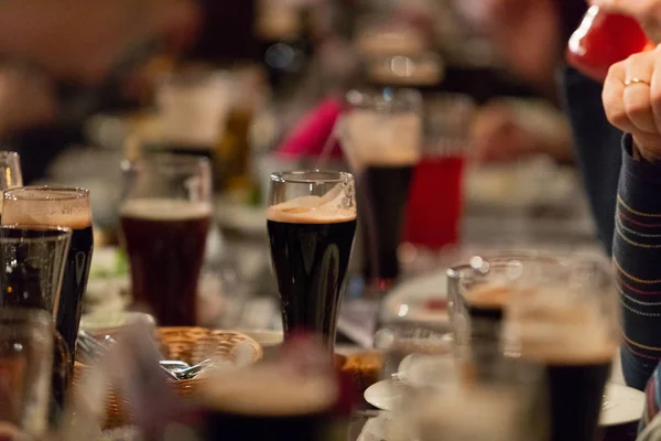 A party. A pub. Bar. Club. A restaurant. Beer glasses with dark beer. Dark beer poured into beer glasses