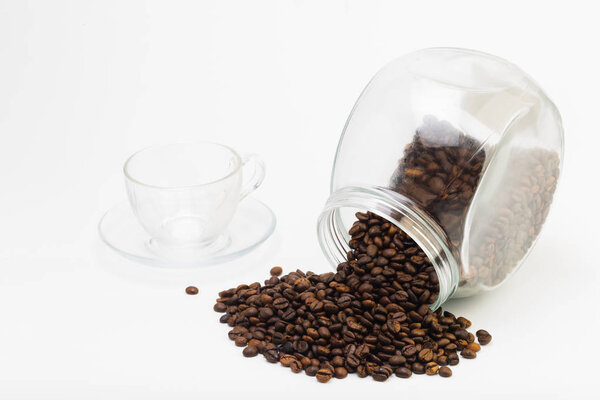 Grains of coffee and a cup of black coffee on a white background, studio light