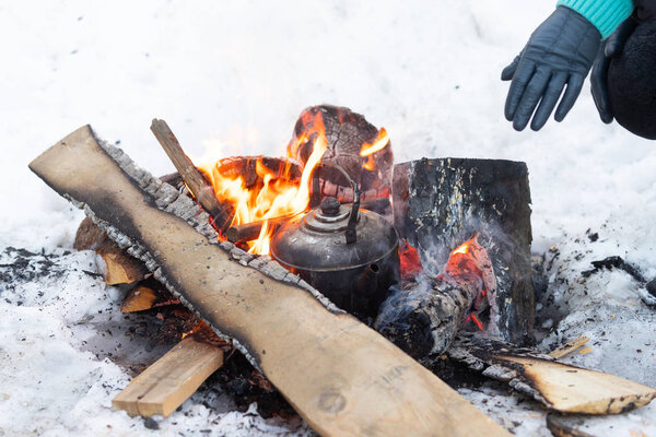 Kettle boils on fire campfire. Cooking on a fire