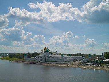 Mavi gökyüzü ile yaz manzara, beyaz bulutlar ve eski bir manastır üzerinde