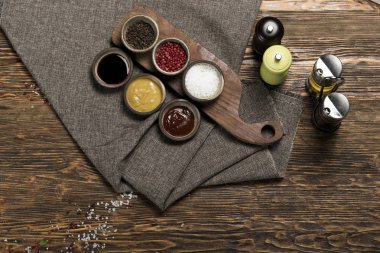 Farklı baharatlar ve soslar ve gri keten masa örtüsü.