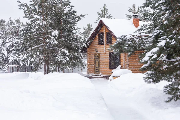 Casa de madera rústica, pinos cubiertos de nieve, grandes derrapes de nieve, nieve. Paisaje rural de invierno hermoso. Año Nuevo, Navidad — Foto de Stock