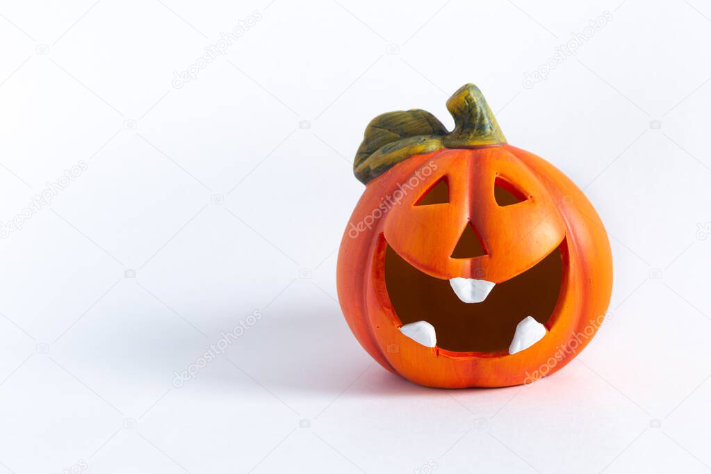Orange decorative cheerful pumpkin lantern on a white background. Halloween, All Saints Day, a traditional fall holiday. Trick or treat. Jack lantern. Postcard. Copy space.