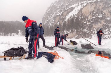 Braies Lake, İtalya - 10 Mart 2018: İtalyan Carabinieri kazmak büyük bir delik derin içine girerek kurtarma dalgıçlar göle, Braies, İtalya için buz