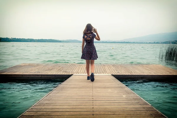 Rıhtımda modellik yapan genç bir kız kameranın önüne bakıyor, Pusiano Gölü, Lecco, İtalya