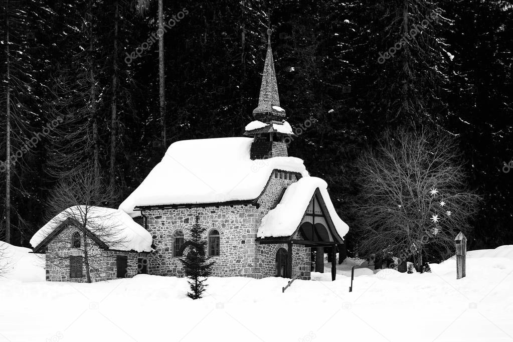 Church and snow covered trees behind, Lake of Braies, Dolomites, South Tyrol, Italy