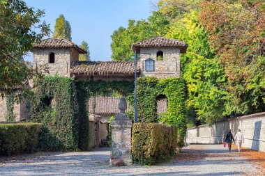 Bir sonbahar yolun doğru Kalesi Grazzano Visconti, Piacenza, İtalya ortasında yürüyen genç çift