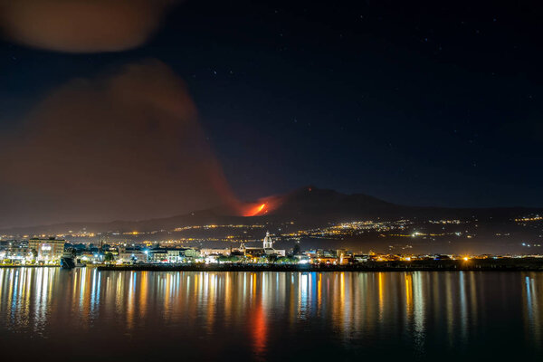 Volcanic eruption and ash plume at nighttime