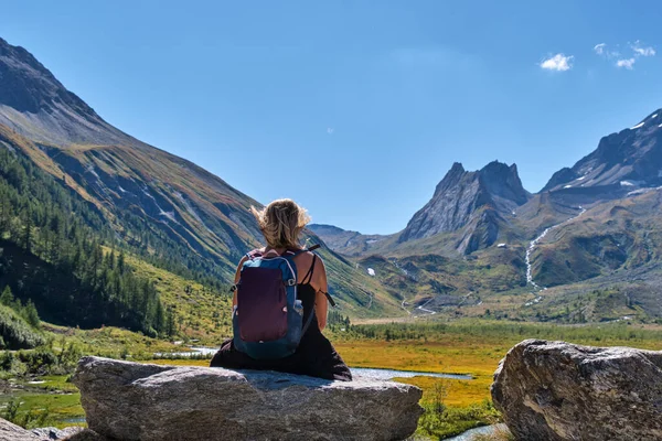 一个女徒步旅行者坐在岩石上 凝视着Val Veny的勃朗峰阿尔卑斯山风景的背景 — 图库照片
