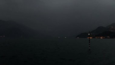 Alacakaranlık Como Gölü 'nde, Bellagio' dan gelen güzel bir alp gölü, yolcuları taşıyan feribot teknelerinin uzaklarındaki sisli dağların manzarasıyla altın ışıkla yıkanmış..