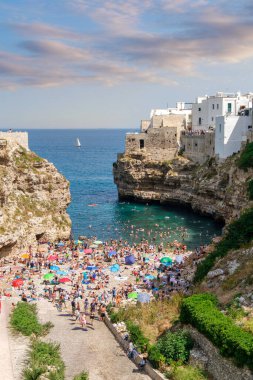 Historic cliffside houses above turquoise Adriatic waters in Polignano a Mare, Apulia, Italy. Iconic summer seascape, tourism and lifestyle destination.