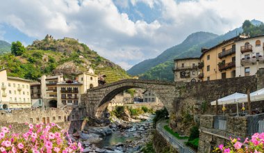 Historic Pont-Saint-Martin bridge and Forte di Bard in Valle dAosta Italy. Scenic Alps, medieval architecture, riverside charm, and cultural heritage.