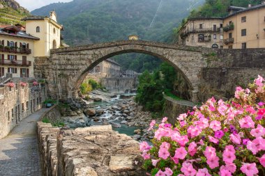 Historic Pont-Saint-Martin bridge and Forte di Bard in Valle dAosta Italy. Scenic Alps, medieval architecture, riverside charm, and cultural heritage.