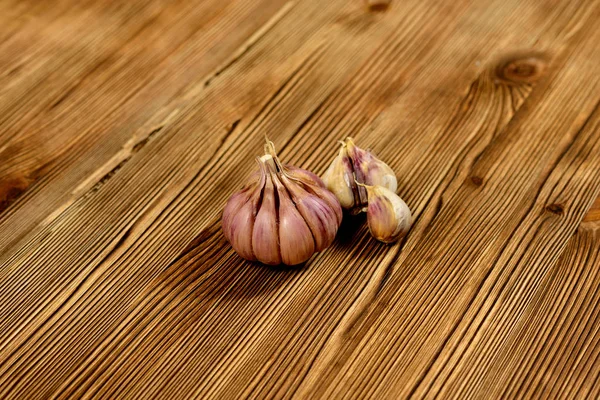 Een Paar Knoflookteentjes Liggen Een Donkere Geweven Houten Achtergrond Close — Stockfoto