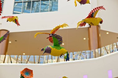 Toplanan renkli kağıt ve yapıştırıcı, bir sürü kuşlar ve çiçekler alışveriş merkezi asmak kubbe altında ince şeffaf halatlar üzerinde. Sağ ek yükü.