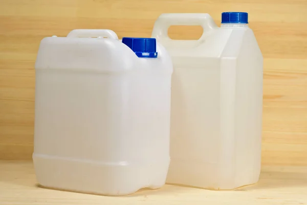 Een Paar Plastic Gallons Van Verschillende Configuratie Houten Achtergrond — Stockfoto