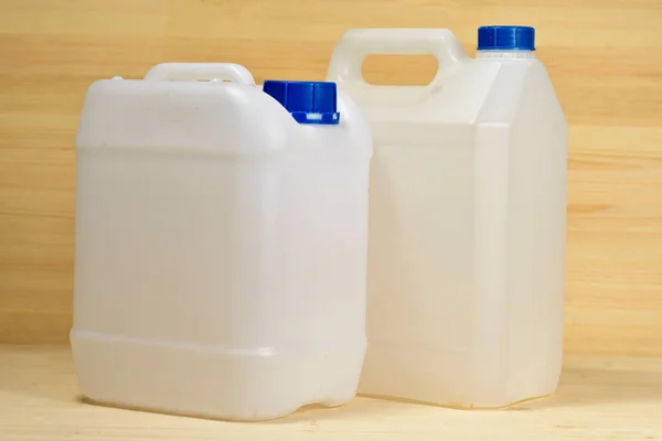 Ett Par Plast Gallons Olika Konfiguration Trä Bakgrund — Stockfoto