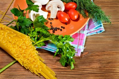 İtalyanca, spagetti lezzetli makarna hazırlanması için bir dizi monte. Bir tablo peçete ve seramik plaka ahşap bir masa üzerine monte