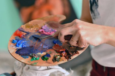Palet renk kızın elinde. gereksiz boyasını temizler. Güzel Sanatlar kavramı