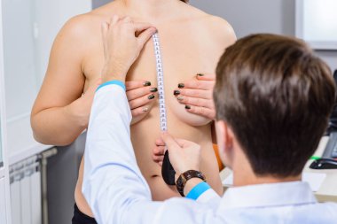 Plastik cerrah incelenmesi. Doktorun elleri ve hastanın göğüs, sakin devlet yakın çekim Meme Merkezi simetri ölçme