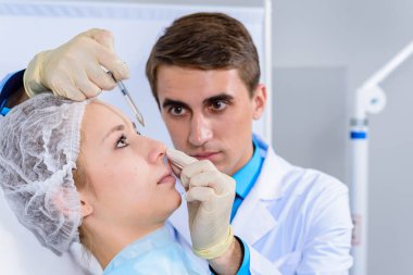 Kozmetik uzmanının elleri yüzüne ve dudaklarına iğne yapıyor. Genç bir kadın güzellik salonunda yüz aşısı yaptırıyor. Yaşlanma, gençleşme ve hidrasyon prosedürleriyle yüzleş. Estetik kozmetoloji. Kapat..