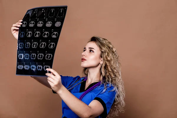 Closeup portrait of intellectual woman healthcare personnel with uniform, looking at partly body x-ray radiographic image, ct scan, mri, isolated background.