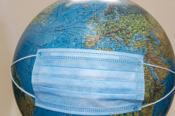 The world with a disposable medical mask due to the Coronavirus (COVID-19). Planet Earth with mask. World medical concept.