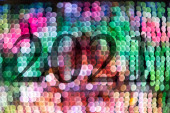 Text mit der Jahreszahl 2021 mit einem Hintergrund aus hellen, unscharfen Lichtern in verschiedenen Schattierungen mit Bokeh-Effekt. Frohes neues Jahr 2021.
