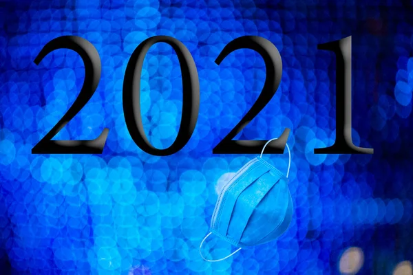 文字与2021年的编号 背景是焦虑症的明亮蓝光与Bokeh效果和一次性蓝色卫生面罩 2021年新年快乐 — 图库照片