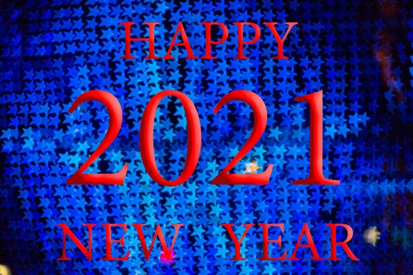 Happy New Year 2021. Background with Bokeh effect with Christmas lights of different colors. Red letters and numbers.