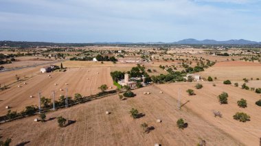 Gün batımında büyük saman topları olan kırsal bir arazinin havadan görünüşü. Campos 'un Yeri, Mallorca Adası, İspanya