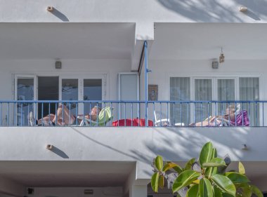 Palma Nova, Balearic Adaları / İspanya; Mart 2014: turistik bir apartmanın balkonunda dinlenen yaşlı turistler