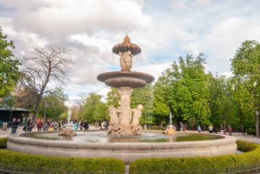 Madrid, İspanya; Nisan 2010: Parque del Buen Retiro 'nun bahçelerindeki Neoklasik Heykel Çeşmesi, yayalarla dolu bir Pazar