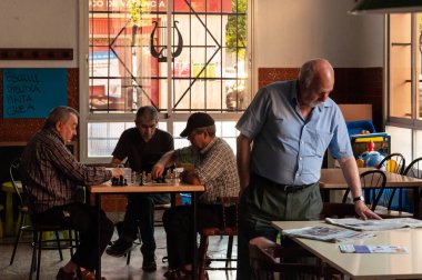Valencia, İspanya; Haziran 2013: Valencia 'daki bir barda dört yaşlı emekli. Üçü satranç oynuyor, dördüncüsü de basını izliyor.