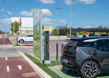 Campos. Balearic Adaları / İspanya; Ağustos 2020: koyu renkli elektrikli araba bir süpermarket otoparkındaki şarj noktasında şarj oluyor