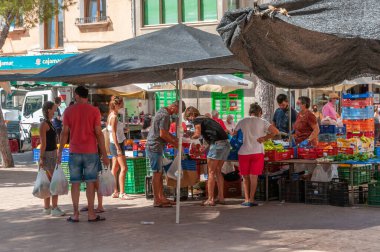 Campos, Balear Adaları / İspanya; Ağustos 2020: Campos 'taki geleneksel sokak pazarında meyve ve sebze tezgahı. Covid-19 'un yeni sosyal önlemleri için eldiven ve maskeli satıcı ve alıcılar