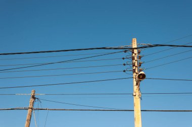 Gün batımında mavi gökyüzünün arka planına sahip iki eski ışık direği.