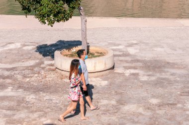 Palma de Mallorca, Balearic Adaları / İspanya; Eylül 2020: Parc de la Mar. Ön planda maskeli iki turist var. Yeni normal