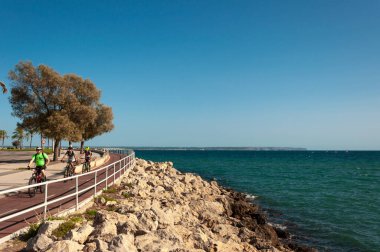 Palma de Mallorca, Balearic Adaları / İspanya; Eylül 2020: Akdeniz kıyısındaki Palma de Mallorca gezinti alanında üç bisikletçiden oluşan grup