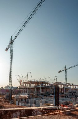 Sa Rapita, Balear Adaları / İspanya; Eylül 2020: Metal inşaat kuleleri bir emlak ajansının reklam direğinin yanında ve mavi gökyüzü bir fon olarak