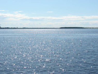 Nehirde güneş ve dalgalar parlıyor.