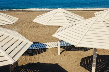 Kum Plajı üzerinde ahşap Beyaz şemsiye