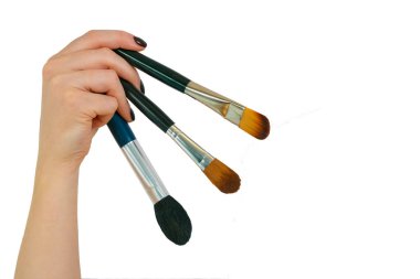 Kadın makyaj fırçaları tutar
