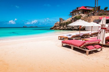 St. Barths, Karayip Adası 'ndaki egzotik sahilde lüks plaj sandalyeleri ve şemsiye..