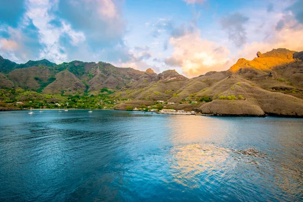 Nuku Hiva, Marquesas Adaları, Fransız Polinezyası. Gün batımında liman ve dağ manzarası.